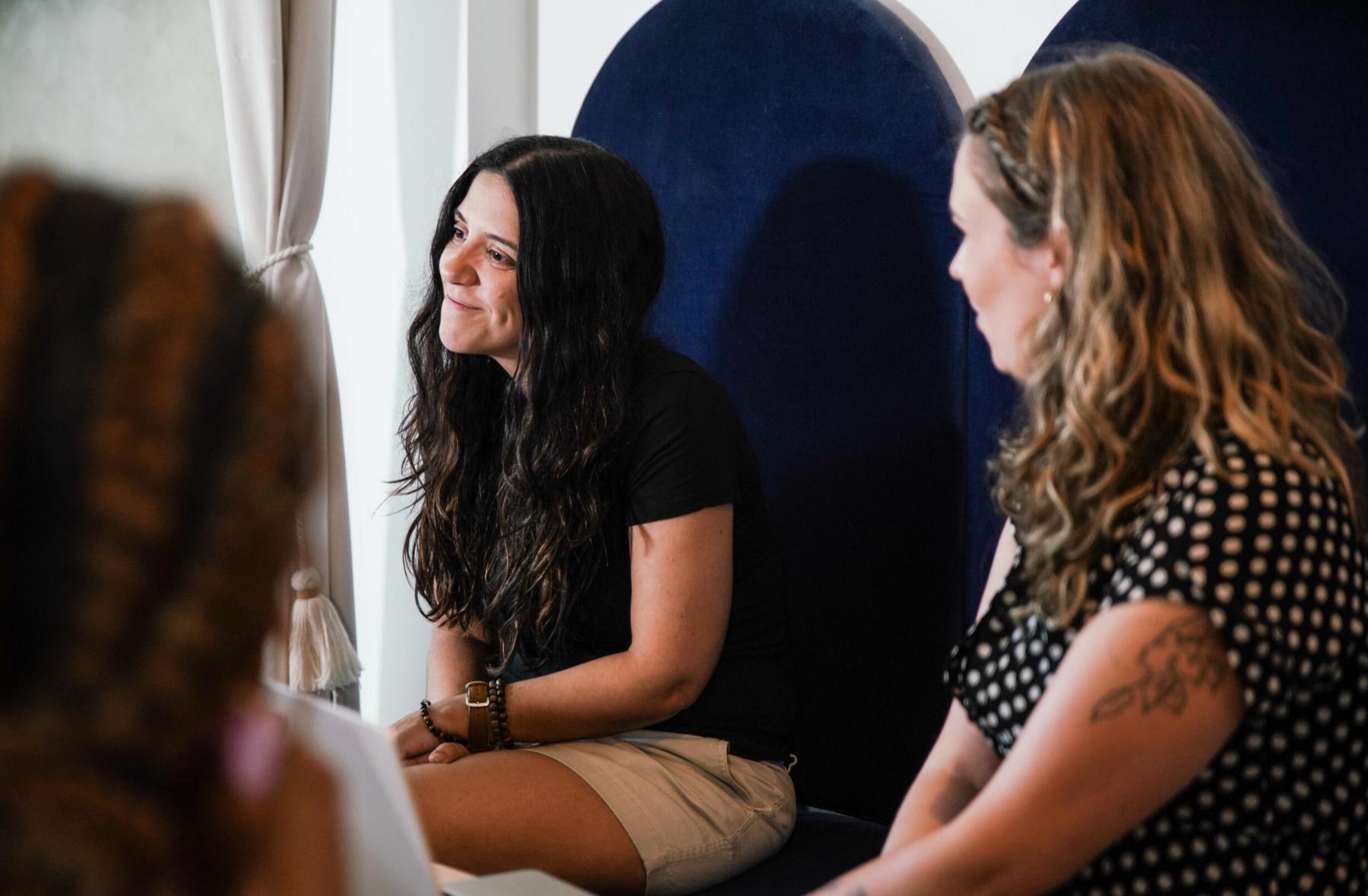 Three people in conversation during a workshop, side light from a window
