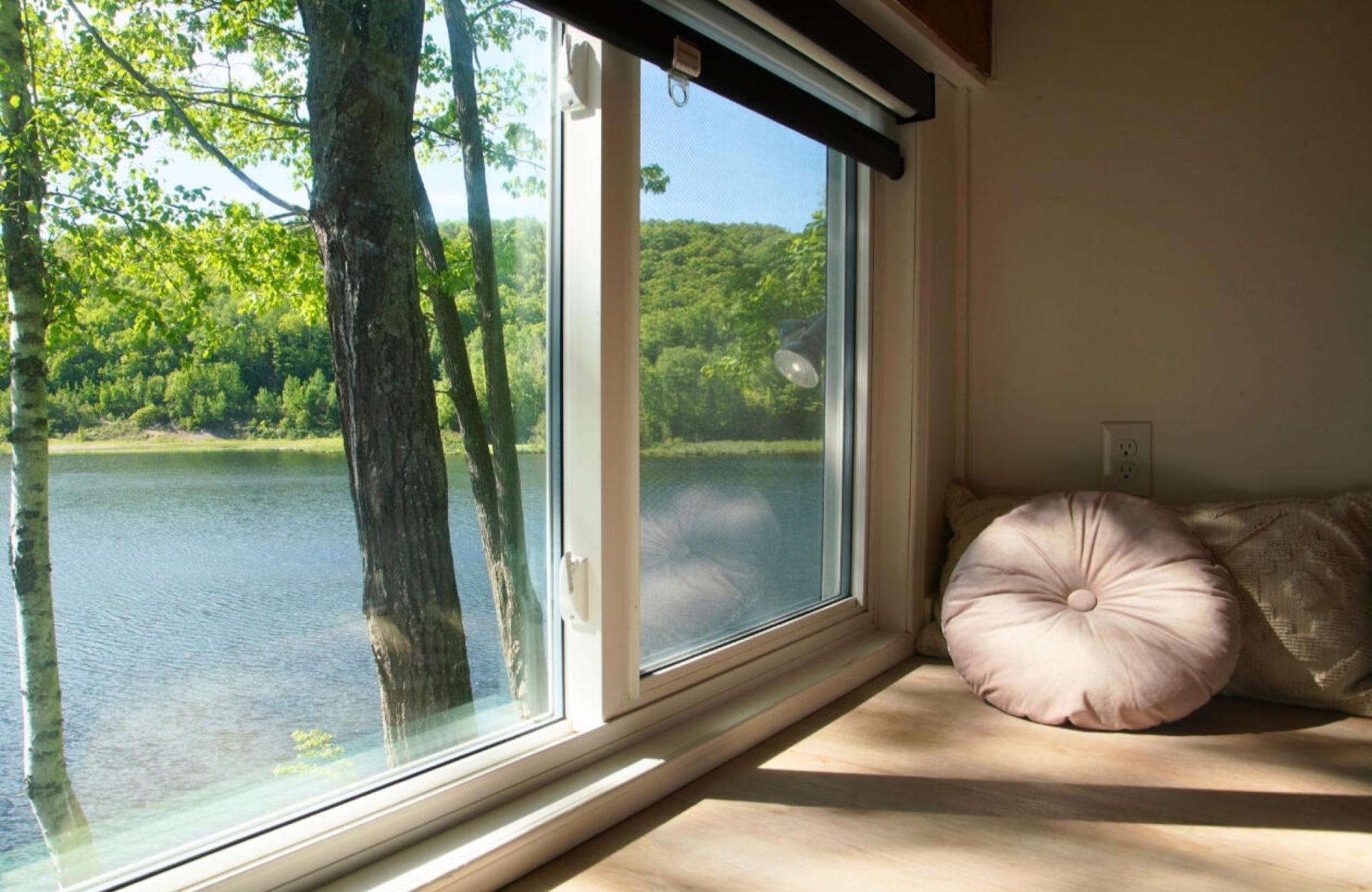 Cushioned window seat in full sun looking directly onto the lake and the far shore