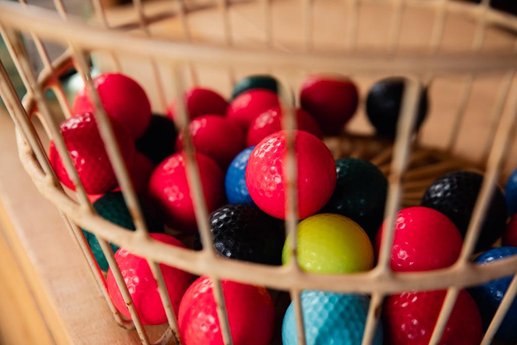 Close frame of coloured mini golf balls in a wire basket